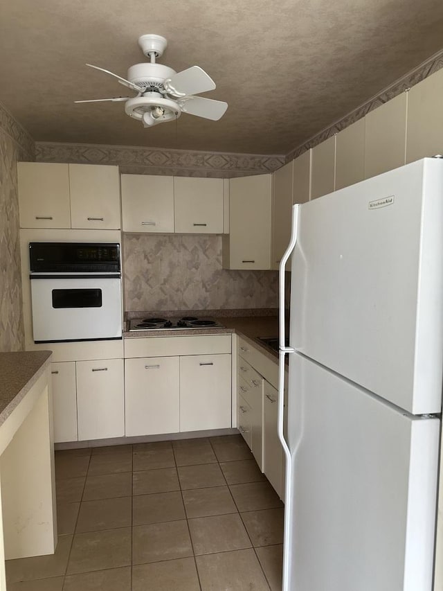 4800 S Chicago Beach Dr Unit 910S, Chicago, IL 60615 - kitchen with white appliances, tile patterned floors, a ceiling fan, and white cabinets