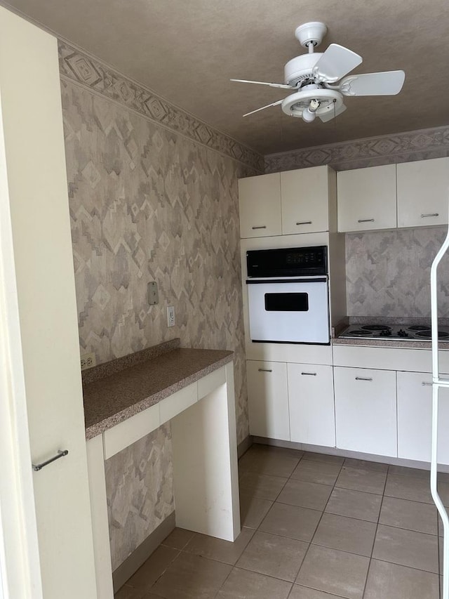 4800 S Chicago Beach Dr Unit 910S, Chicago, IL 60615 - kitchen with oven, black electric cooktop, light tile patterned floors, a ceiling fan, and white cabinetry