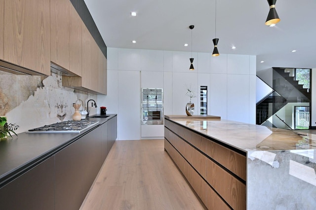 332 W Fremont Ave, Elmhurst, IL 60126 - kitchen with appliances with stainless steel finishes, modern cabinets, light wood-style flooring, tasteful backsplash, and recessed lighting