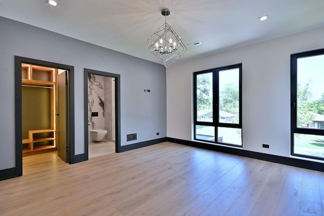 332 W Fremont Ave, Elmhurst, IL 60126 - unfurnished bedroom featuring multiple windows, light wood-style flooring, and a chandelier