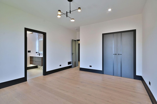 332 W Fremont Ave, Elmhurst, IL 60126 - unfurnished bedroom featuring light wood-style flooring, a chandelier, a closet, and ensuite bathroom