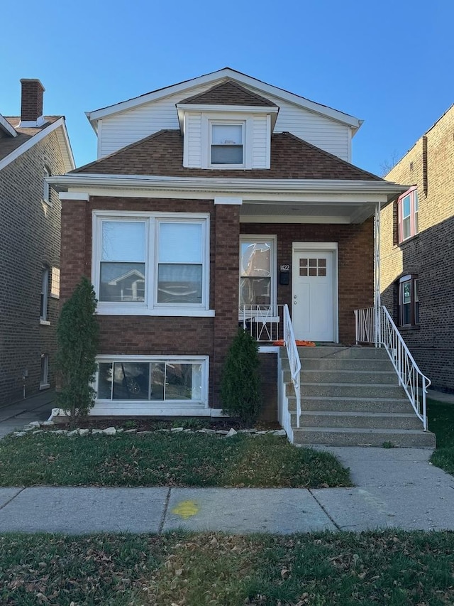 1422 N Latrobe Ave, Chicago, IL 60651 - view of front of house featuring covered porch, brick siding, and roof with shingles