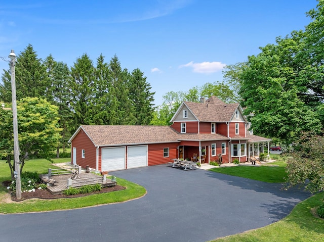 12002 Patterson Rd, Durand, IL 61024 - view of front of home with an attached garage, a porch, a front yard, asphalt driveway, and roof with shingles