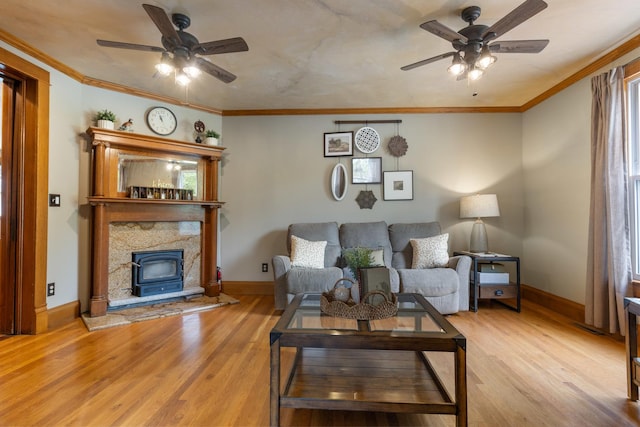 12002 Patterson Rd, Durand, IL 61024 - living room featuring ceiling fan, light wood-style flooring, ornamental molding, and a wood stove