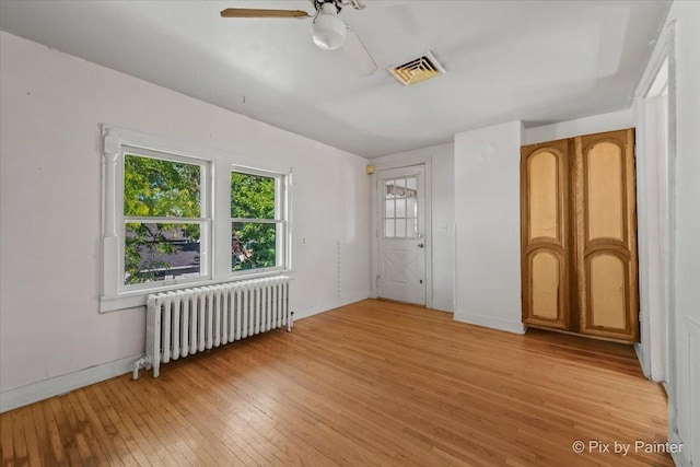 18 Madison St, Algonquin, IL 60102 - unfurnished bedroom with radiator heating unit, light wood-style floors, and a ceiling fan