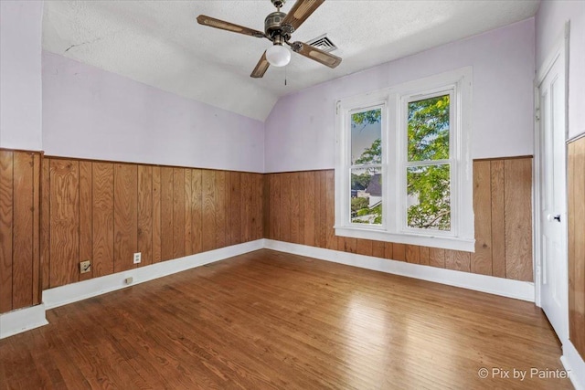 18 Madison St, Algonquin, IL 60102 - unfurnished room featuring wood finished floors, a ceiling fan, a wainscoted wall, lofted ceiling, and a textured ceiling