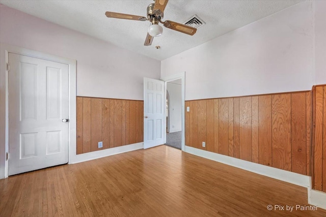 18 Madison St, Algonquin, IL 60102 - unfurnished room featuring wainscoting, wood finished floors, wood walls, a textured ceiling, and ceiling fan