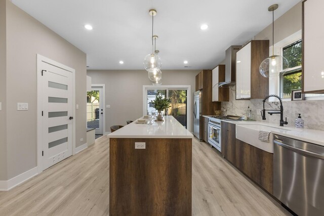 5901 W Erie St, Chicago, IL 60644 - kitchen featuring stainless steel appliances, modern cabinets, wall chimney range hood, a sink, and recessed lighting