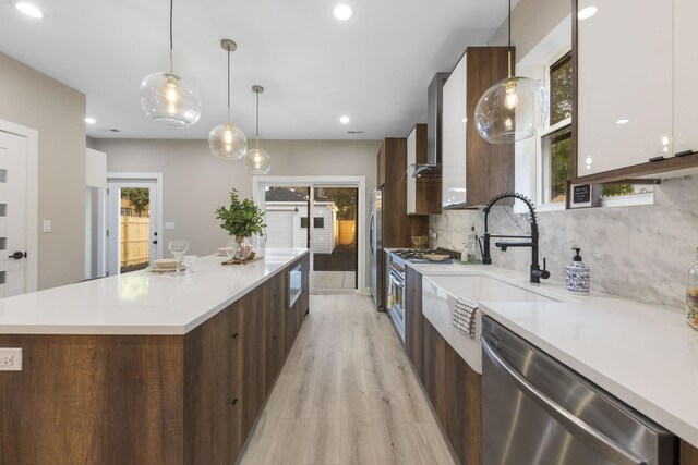 5901 W Erie St, Chicago, IL 60644 - kitchen featuring modern cabinets, appliances with stainless steel finishes, light wood-style flooring, a large island, and a sink