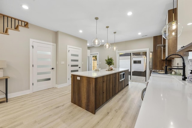 5901 W Erie St, Chicago, IL 60644 - kitchen featuring modern cabinets, a spacious island, light wood-style floors, light countertops, and recessed lighting