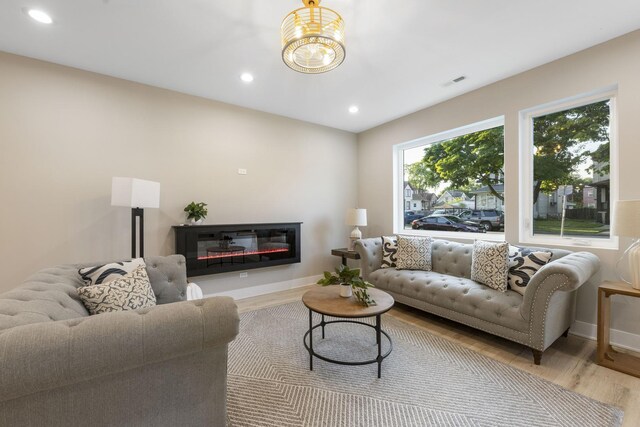 5901 W Erie St, Chicago, IL 60644 - living room featuring wood finished floors, recessed lighting, baseboards, and a glass covered fireplace