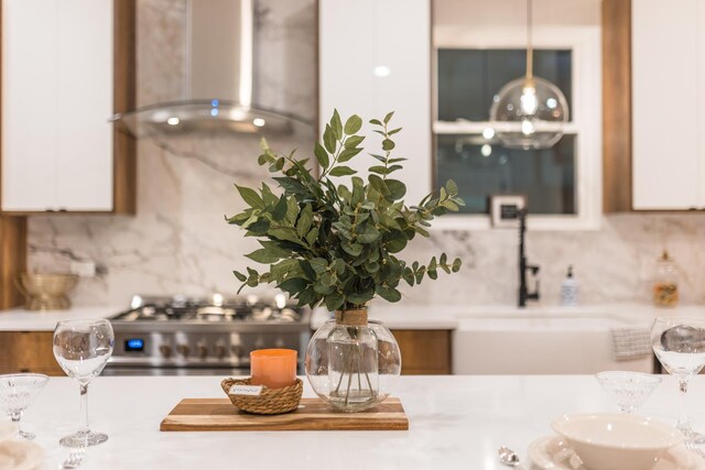 5901 W Erie St, Chicago, IL 60644 - kitchen featuring wall chimney exhaust hood, backsplash, white cabinetry, and stainless steel range oven