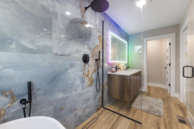 5901 W Erie St, Chicago, IL 60644 - full bath with a marble finish shower, vanity, a soaking tub, and wood finished floors