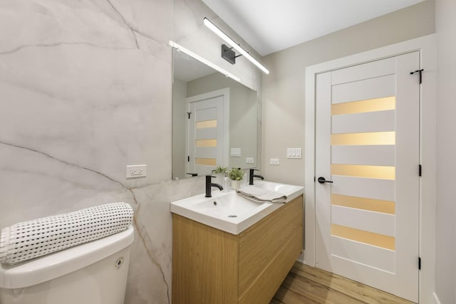 5901 W Erie St, Chicago, IL 60644 - bathroom featuring double vanity, toilet, and wood finished floors