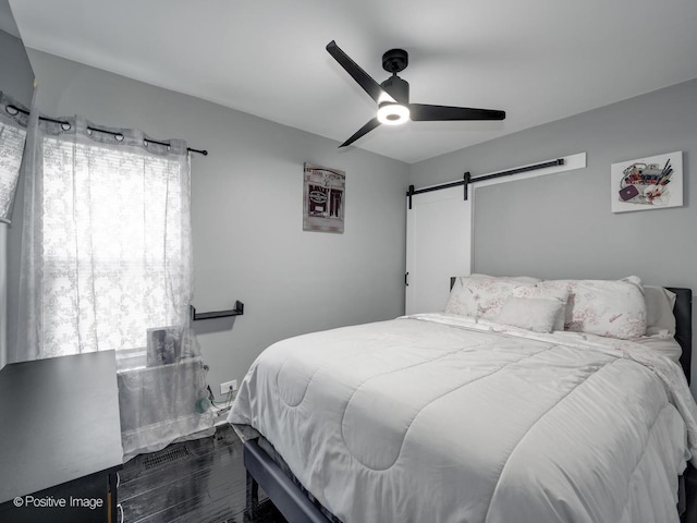 1246 Marengo Ave, Forest Park, IL 60130 - bedroom with a barn door, ceiling fan, and dark wood-type flooring