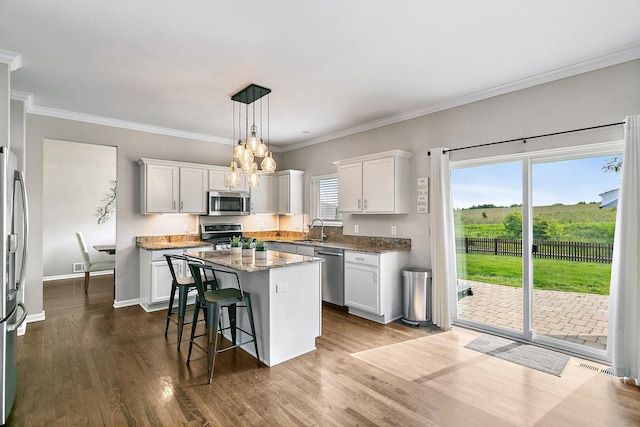 1S215 S Hyde Park, Geneva, IL 60134 - kitchen featuring appliances with stainless steel finishes, a center island, white cabinetry, dark wood-type flooring, and crown molding