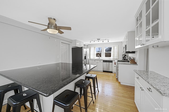 5213 Fairview Ave, Downers Grove, IL 60515 - kitchen with stainless steel appliances, a breakfast bar, a ceiling fan, light wood-style flooring, and white cabinetry