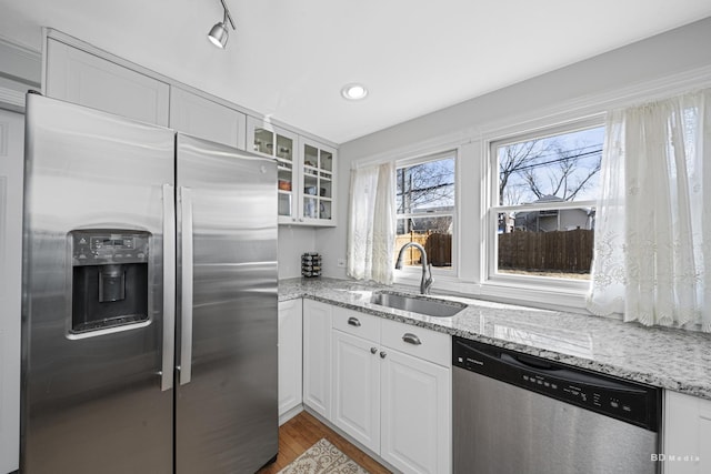 5213 Fairview Ave, Downers Grove, IL 60515 - kitchen with appliances with stainless steel finishes, a sink, glass insert cabinets, white cabinetry, and light stone counters