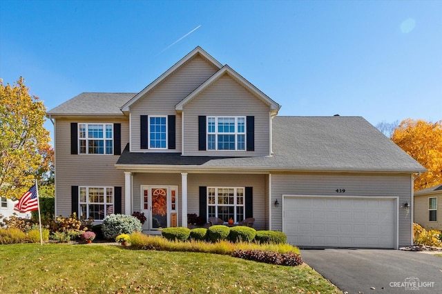 439 Camden Cir, Oswego, IL 60543 - view of front of house with a garage, a front lawn, and asphalt driveway