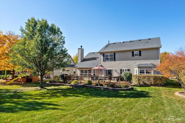 439 Camden Cir, Oswego, IL 60543 - rear view of house with a chimney, a deck, a yard, and a playground