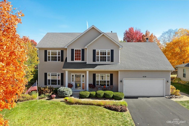 439 Camden Cir, Oswego, IL 60543 - traditional-style home featuring asphalt driveway, a garage, a front yard, and covered porch