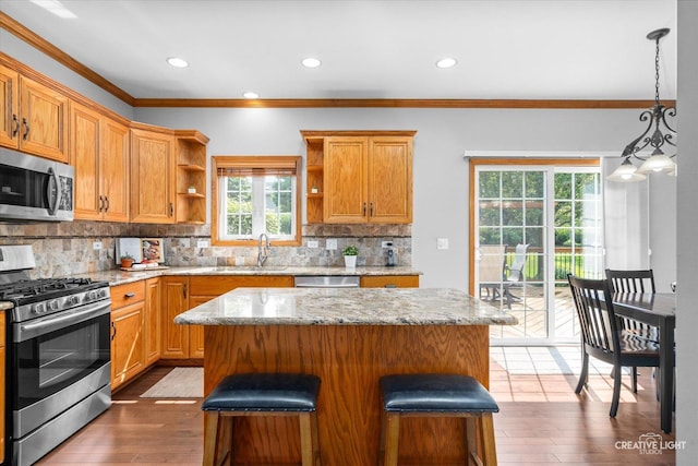 439 Camden Cir, Oswego, IL 60543 - kitchen with stainless steel appliances, open shelves, backsplash, ornamental molding, and a kitchen island