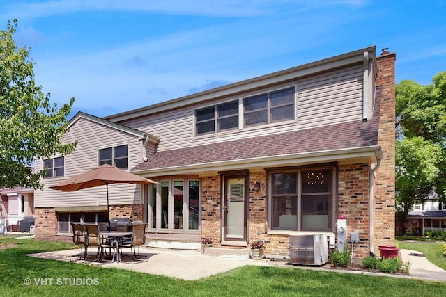 3026 N Stratford Rd, Arlington Heights, IL 60004 - back of property with brick siding, a patio area, and a lawn