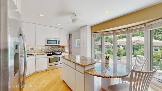 3026 N Stratford Rd, Arlington Heights, IL 60004 - kitchen featuring appliances with stainless steel finishes, a kitchen island, healthy amount of natural light, decorative backsplash, and recessed lighting