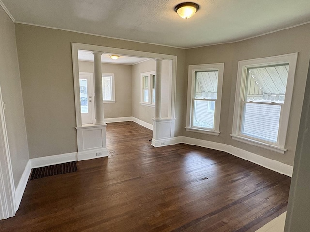 153 N Entrance Ave, Kankakee, IL 60901 - empty room with decorative columns, crown molding, and dark wood-style flooring