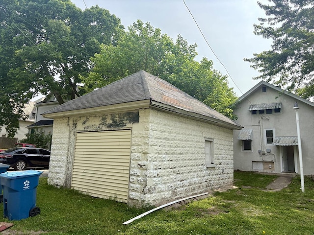 153 N Entrance Ave, Kankakee, IL 60901 - view of side of home featuring a yard, a shingled roof, an outdoor structure, and a garage