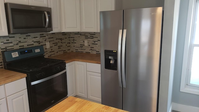 402 W Fulton St, Polo, IL 61064 - kitchen with appliances with stainless steel finishes, butcher block countertops, backsplash, white cabinets, and wood finished floors
