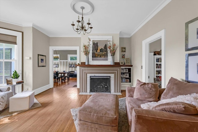 320 E Locust St, Watseka, IL 60970 - living room featuring plenty of natural light, crown molding, a chandelier, light wood-style floors, and a brick fireplace