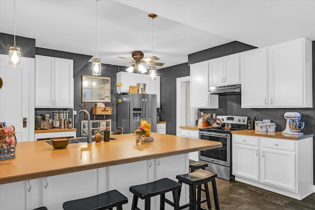 320 E Locust St, Watseka, IL 60970 - kitchen with appliances with stainless steel finishes, under cabinet range hood, a breakfast bar area, and light countertops