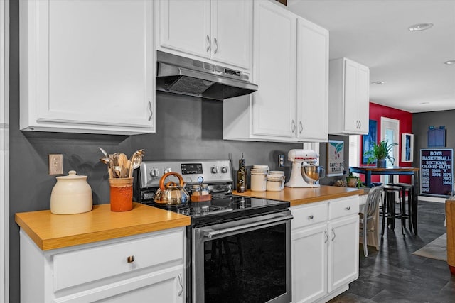 320 E Locust St, Watseka, IL 60970 - kitchen with stainless steel electric stove, under cabinet range hood, white cabinets, light countertops, and recessed lighting