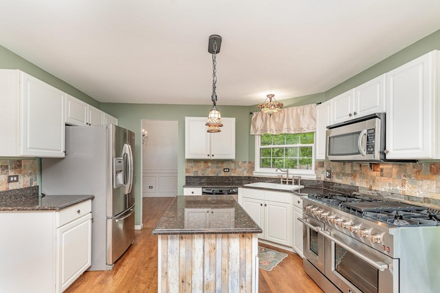 2015 Steward Ln, Plainfield, IL 60586 - kitchen with stainless steel appliances, a sink, tasteful backsplash, dark stone countertops, and light wood-style flooring