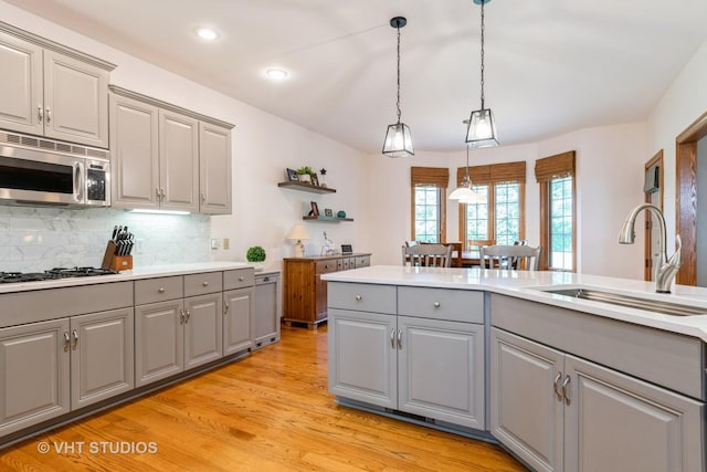 8820 Wilcox Ct, Newark, IL 60541 - kitchen with gray cabinetry, stainless steel microwave, decorative backsplash, light wood-type flooring, and recessed lighting