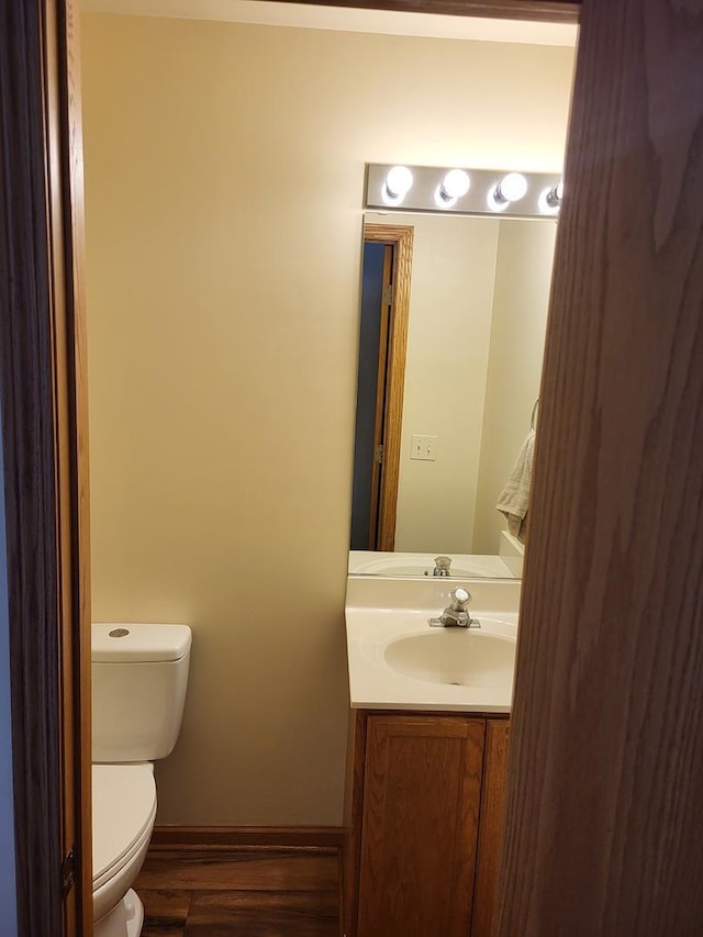 831 Hickory Ct, Marengo, IL 60152 - half bath with vanity, toilet, wood finished floors, and baseboards