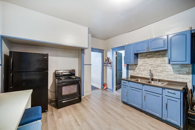 1340 E 76th St, Chicago, IL 60619 - kitchen with black appliances, a sink, blue cabinetry, and light wood finished floors
