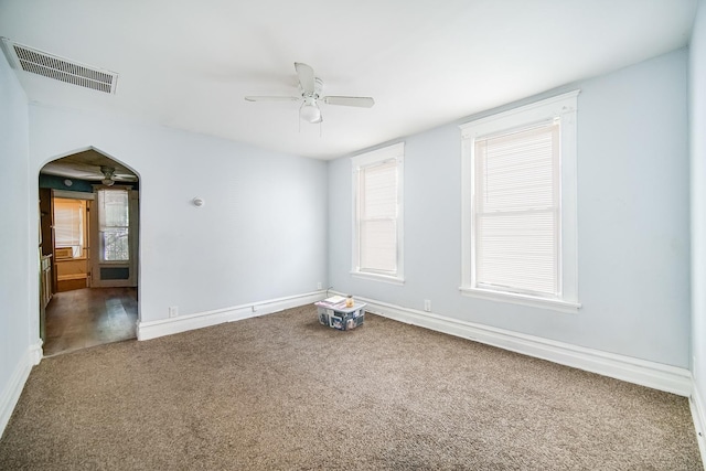 1340 E 76th St, Chicago, IL 60619 - carpeted empty room featuring ceiling fan, arched walkways, and baseboards