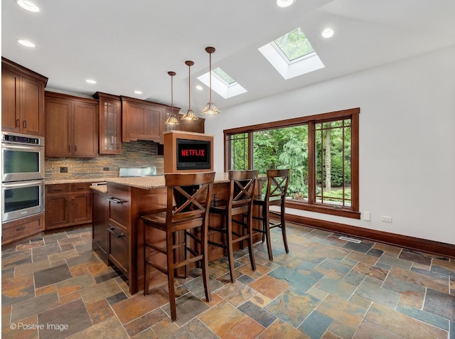 456 S Julian St, Naperville, IL 60540 - kitchen featuring stainless steel double oven, a skylight, tasteful backsplash, stone tile flooring, and recessed lighting