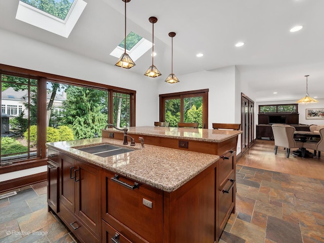 456 S Julian St, Naperville, IL 60540 - kitchen with stone tile flooring, a skylight, an island with sink, open floor plan, and pendant lighting