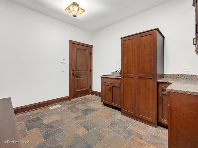456 S Julian St, Naperville, IL 60540 - kitchen featuring dark stone finish flooring, brown cabinets, and light stone counters