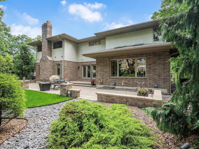 456 S Julian St, Naperville, IL 60540 - back of property with stucco siding, a patio area, a chimney, brick siding, and entry steps