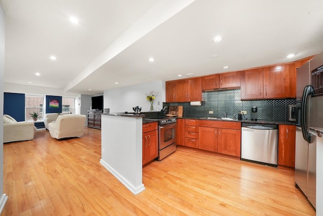 40 E 9th St Unit 1807, Chicago, IL 60605 - kitchen featuring appliances with stainless steel finishes, backsplash, a peninsula, light wood finished floors, and recessed lighting