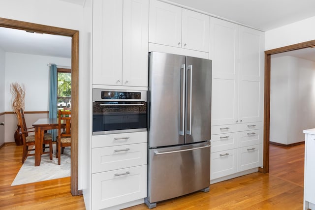 1125 Huntleigh Dr, Naperville, IL 60540 - kitchen with appliances with stainless steel finishes, light wood-style floors, white cabinets, and baseboards