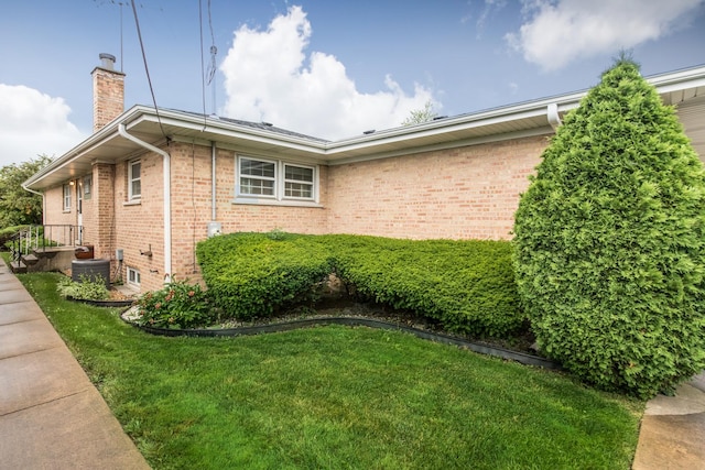 8560 W Winona St, Chicago, IL 60656 - view of home's exterior featuring a chimney, brick siding, and a yard