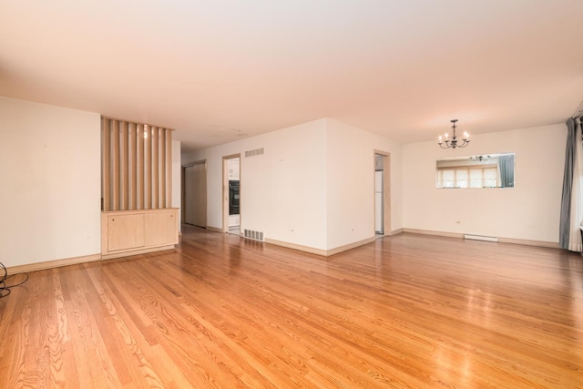 8560 W Winona St, Chicago, IL 60656 - spare room with a chandelier, light wood-style flooring, and baseboard heating