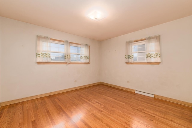8560 W Winona St, Chicago, IL 60656 - empty room featuring healthy amount of natural light, wood finished floors, and a baseboard heating unit