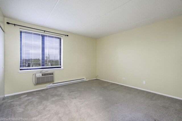 9737 N Fox Glen Dr Unit 4A, Niles, IL 60714 - carpeted spare room with a wall mounted air conditioner, a baseboard heating unit, baseboards, and a textured ceiling