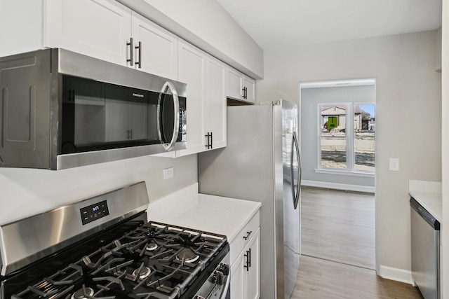 17240 Roy St, Lansing, IL 60438 - kitchen featuring appliances with stainless steel finishes, light countertops, white cabinetry, wood finished floors, and baseboards